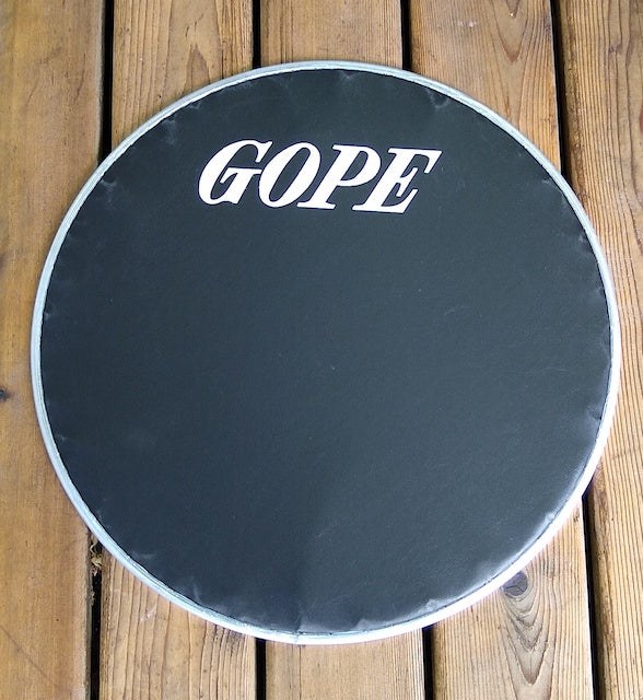 20 inch GOPE drum head for surdo. Black napa head on a wood backdrop