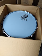 Timbra surdo in a shipping box. Timbra logo on the drum head. 