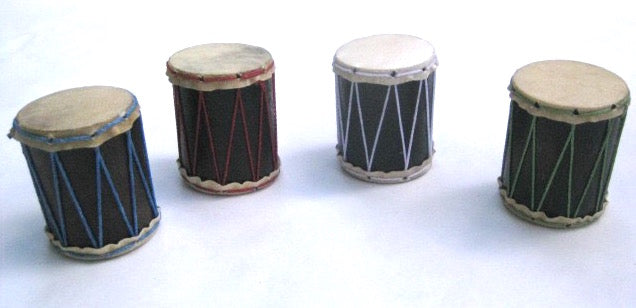 Four teeny hand-made shakers that look like little drums. All different colors in a white background.